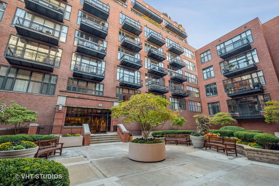 Front view of a multi-story brick apartment building with balconies.