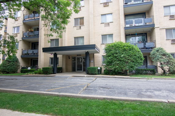 Front view of a multi-story apartment building with balconies.