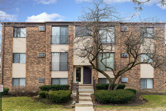 Front view of a two-story apartment building with brick facade and balconies.