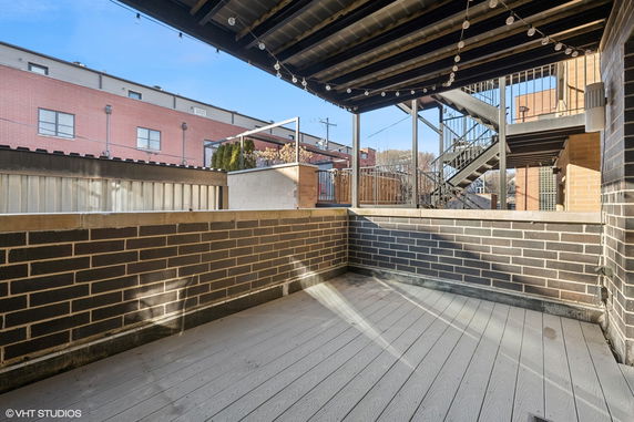 Outdoor rooftop area with brick walls and string lights.