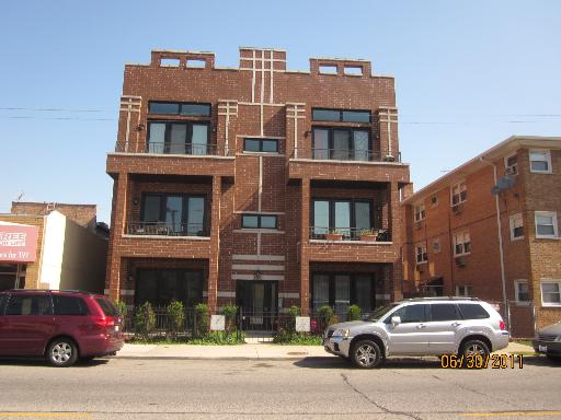 Front view of a multi-story brick building with balconies.