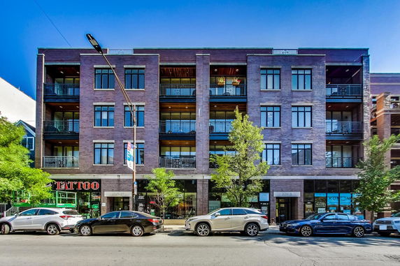 Front view of a multi-story building with balconies and large windows.