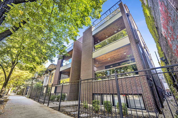 Front view of a modern multi-story brick building with balconies.