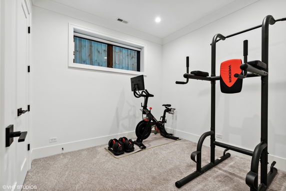 Home gym area with exercise equipment including a bike and weight machine.