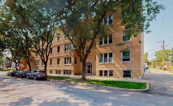 Front view of a multi-story brick apartment building.