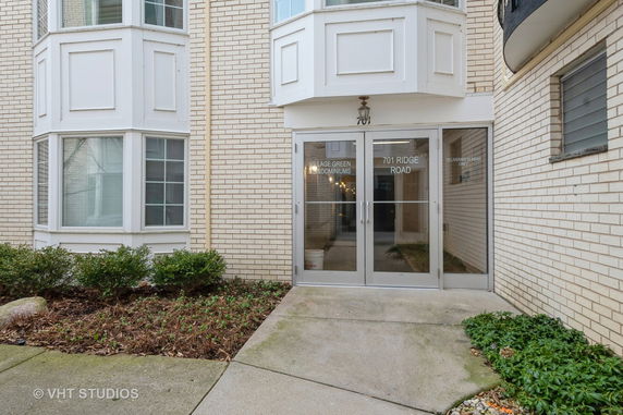 Front view of a building with glass doors and bay windows.