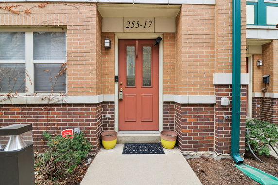 Front view of a building entrance with a red door and brick exterior.