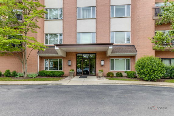 Front view of a multi-story building with brick facade and large entrance.