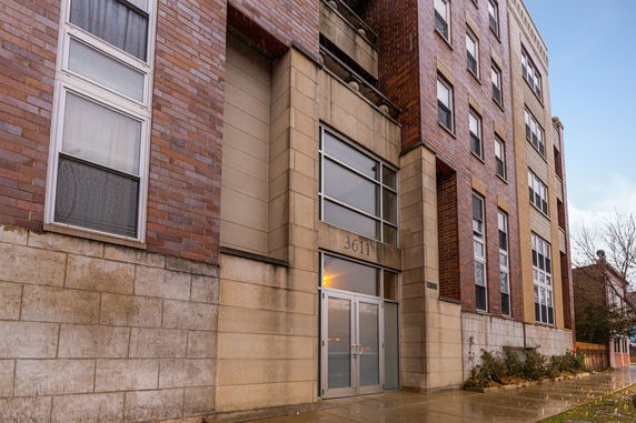 Front view of a multi-story apartment building with a brick and stone exterior.
