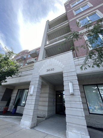 Front view of a multi-story building with balconies and entrance.