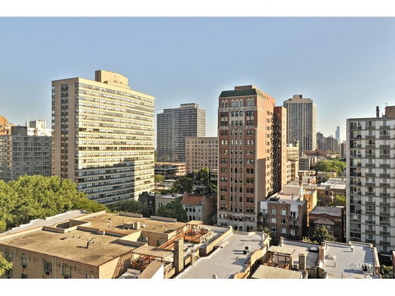 Panoramic view of city buildings from a rooftop.