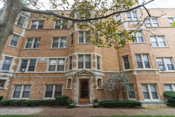 Front view of a multi-story brick building with decorative stone elements.