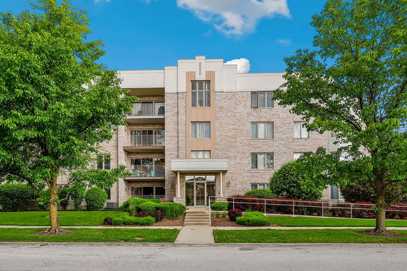 Front view of a multi-story apartment building with a central entrance.