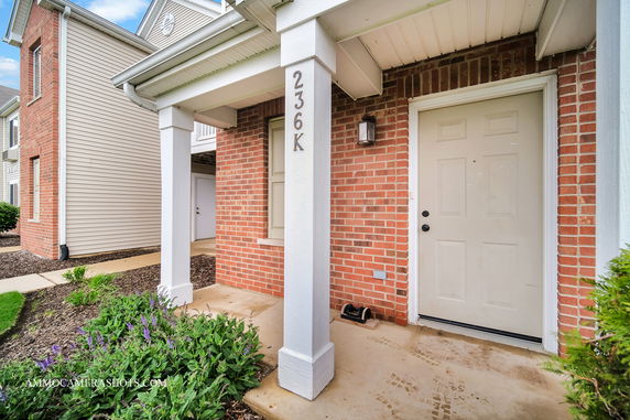Front view of a brick and siding apartment building entrance.