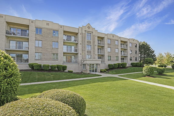 Front view of a four-story apartment building with balconies.