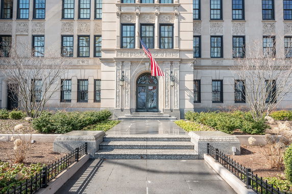 Front view of a large, ornate building with multiple windows and decorative stonework.