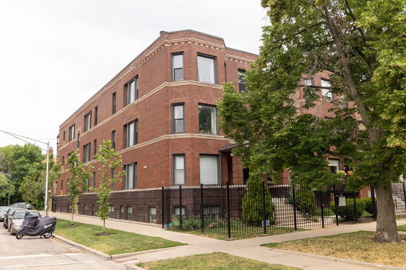Front view of a brick multi-story apartment building.