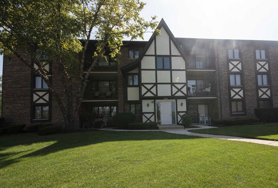 Front view of a multi-story residential building with Tudor-style architectural elements.
