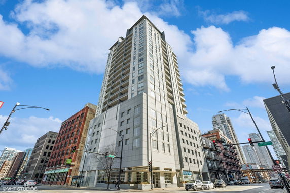 Front view of a tall, modern apartment building in an urban setting.