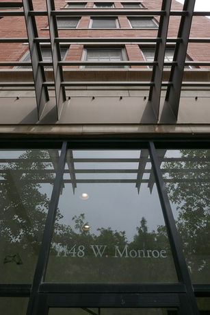 Front view of a multi-story brick building with large windows.