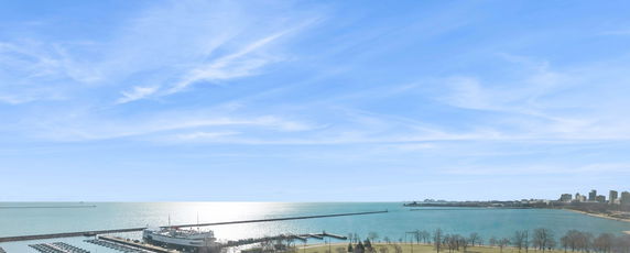 Panoramic view of a large body of water with a dock and a city skyline in the background.