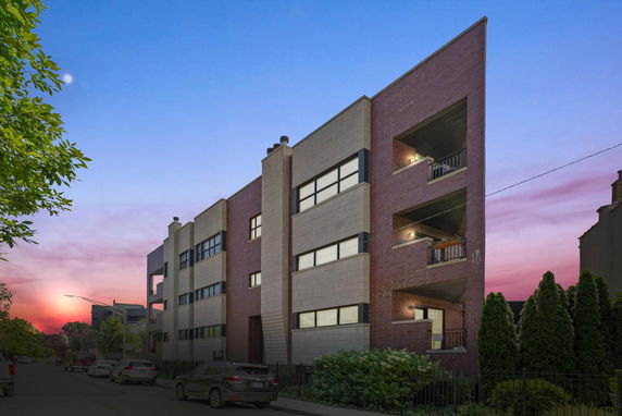 Front view of a multi-story building with large windows and balconies.
