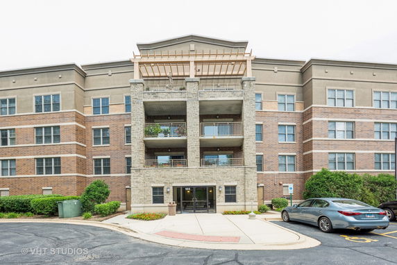 Front view of a multi-story apartment building with balconies.