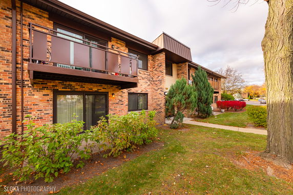 Front view of a two-story brick apartment building with balconies.
