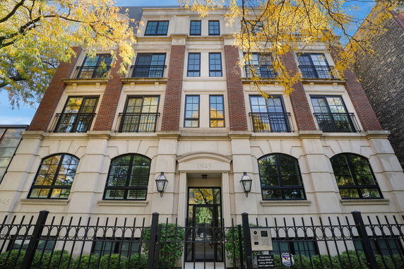 Front view of a multi-story building with large windows and a brick facade.