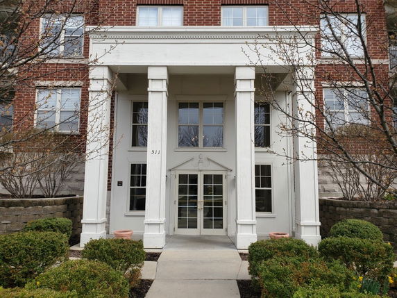Front view of a brick building entrance with columns.