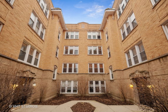 Front view of a multi-story brick building with multiple windows.