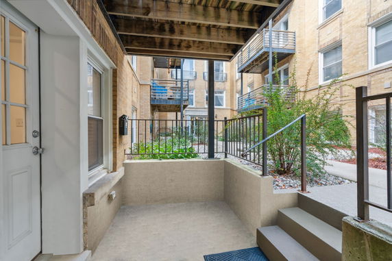 View of an apartment building's courtyard with stairs and railings.