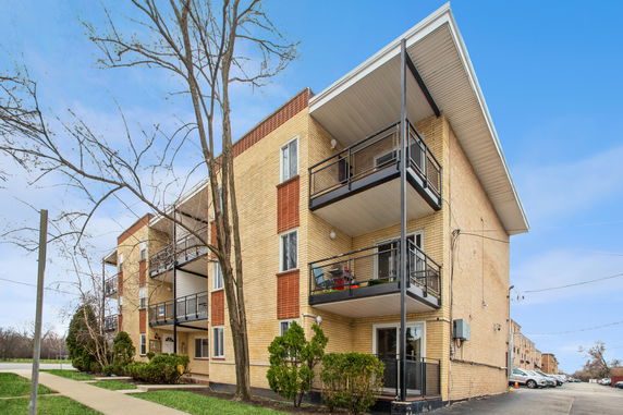 Front view of a multi-story apartment building with balconies.