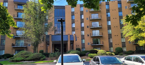 Front view of a multi-story apartment building with balconies.