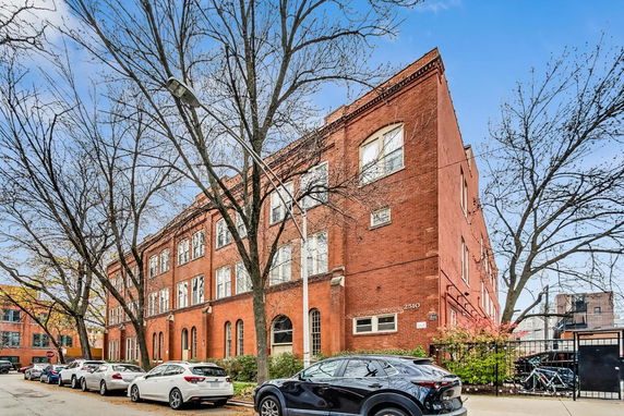 Front view of a multi-story brick building with multiple windows.