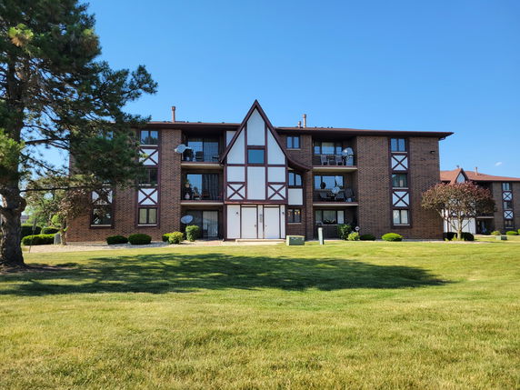 Front view of a multi-story brick building with Tudor-style elements.