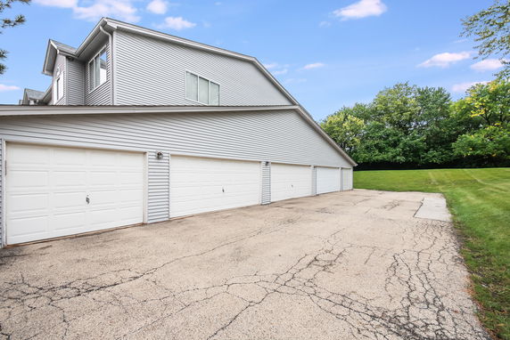 Outdoor parking area with multiple garage doors on a large building.