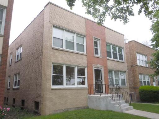 Front view of a two-story brick building with multiple windows and a central entrance.