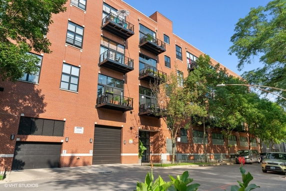 Front view of a multi-story brick building with balconies.