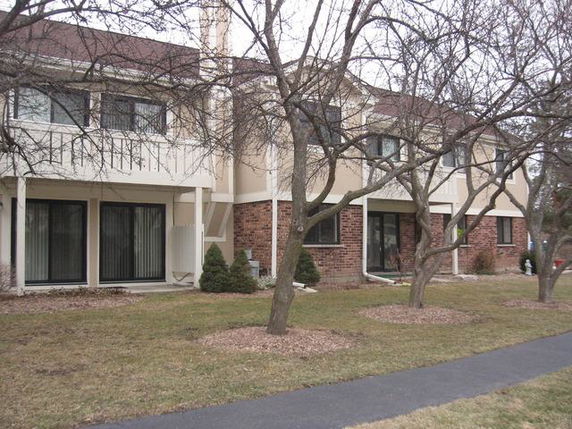 Front view of a multi-story residential building with balconies and large windows.