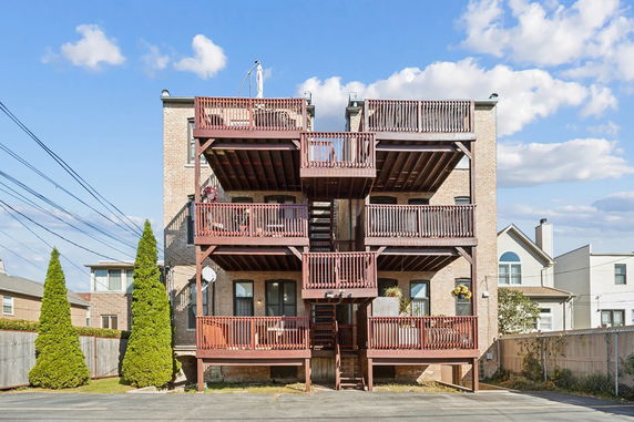 Rear view of a multi-story brick building with multiple balconies.