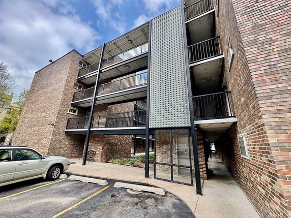 Front view of a multi-story brick building with balconies.