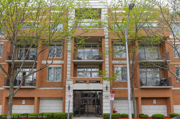 Front view of a multi-story brick apartment building with balconies.
