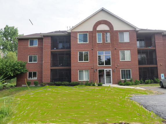 Front view of a three-story brick apartment building.