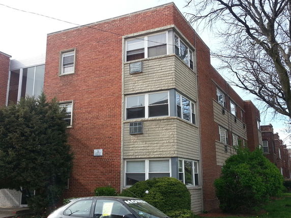 Front view of a three-story brick apartment building.