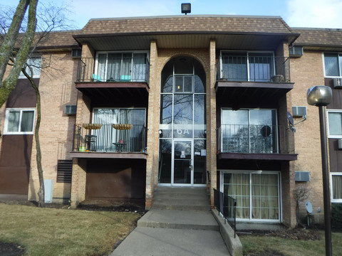 Front view of a multi-story apartment building with balconies.