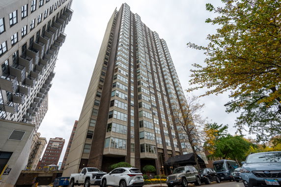 Front view of a tall apartment building with numerous windows and balconies.