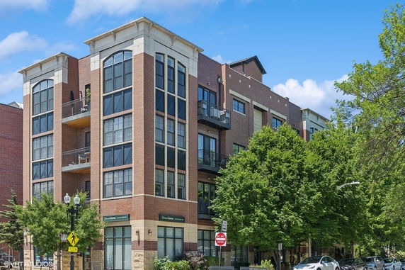 Front view of a multi-story brick building with large windows and balconies.