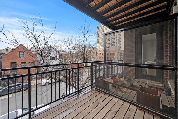 View from a balcony overlooking a street with houses and buildings.