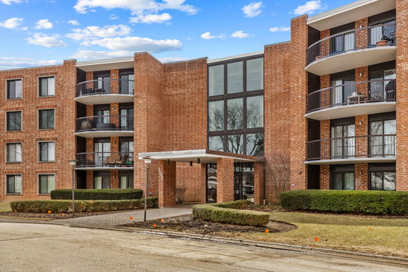 Front view of a multi-story brick building with balconies.